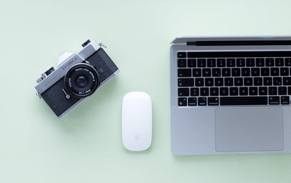 Draufsicht auf Laptop, Maus und Kamera - es geht um einen Beitrag zum Thema liebste Marketing Tools der Onlinerinnen