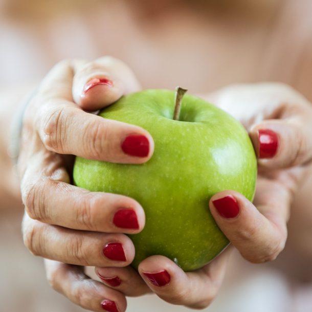 grüner Apfel liegt in zwei Händen - das Titelbild zum Beitrag User Generated Content und auch für den Beitrag "Wie du eine Danke-Seite optimal nutzt