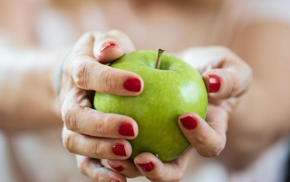 grüner Apfel liegt in zwei Händen - das Titelbild zum Beitrag User Generated Content